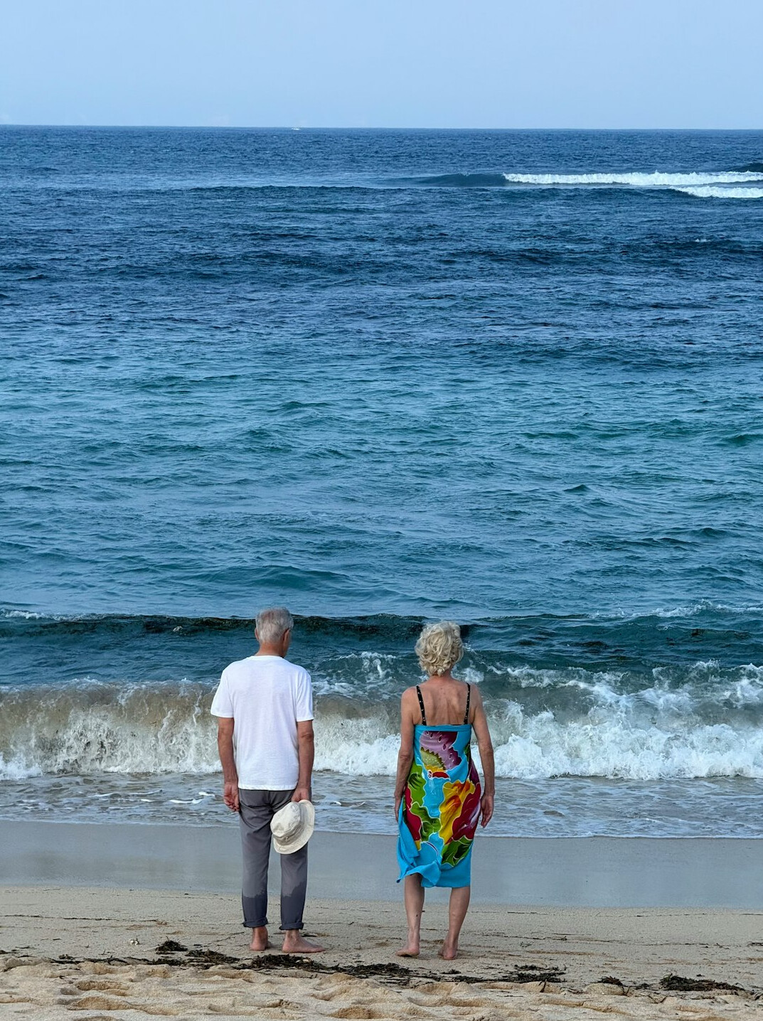 retired couple walking on beach