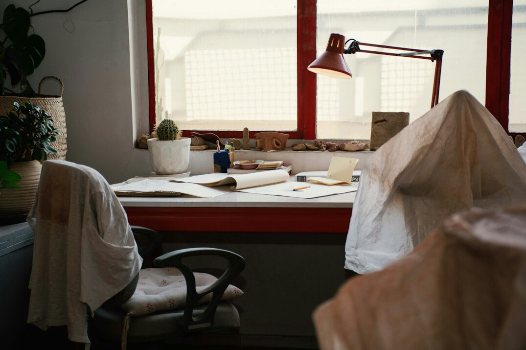 Documents, calculator and coffee cup on a bright wooden desk